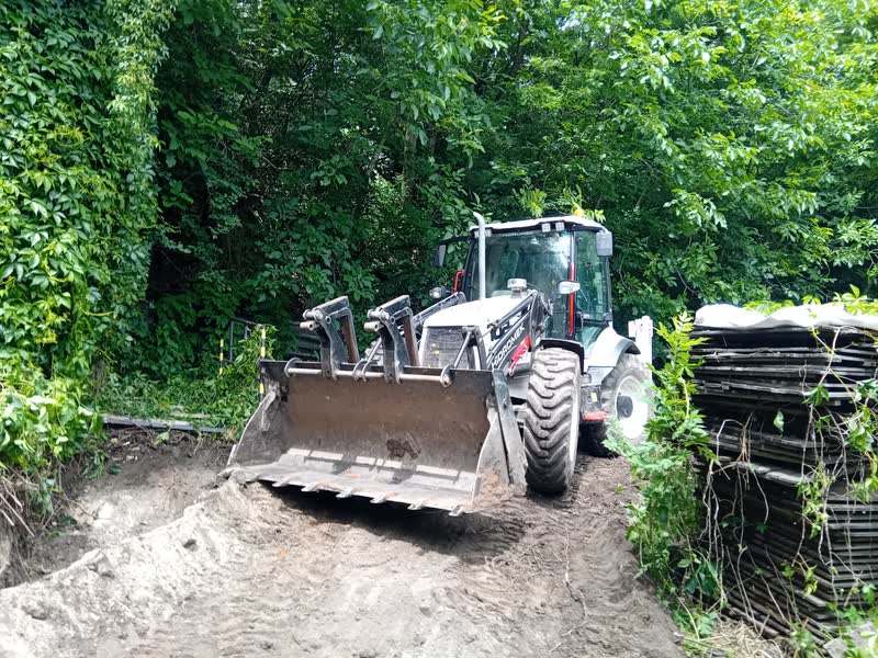 Traktorbagr v úzkém přístupu k pozemku