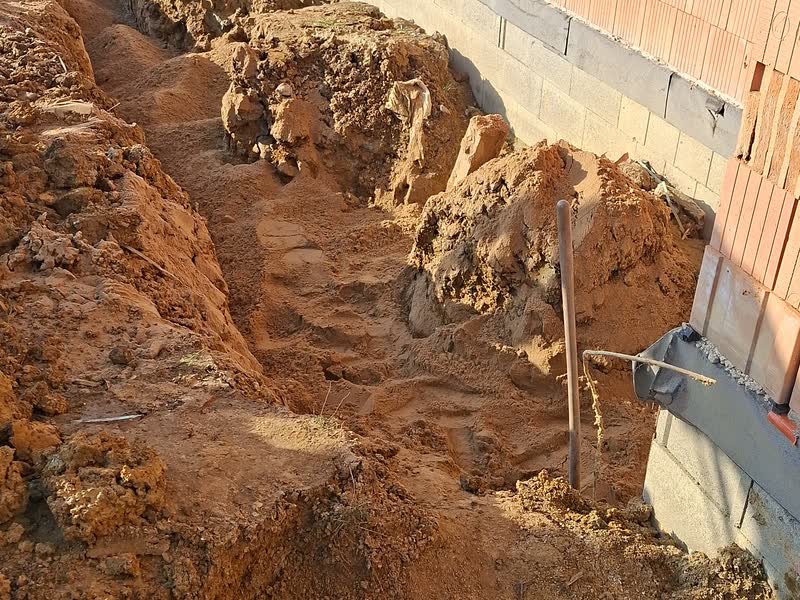 Výkop pro drenáž kolem základů domu